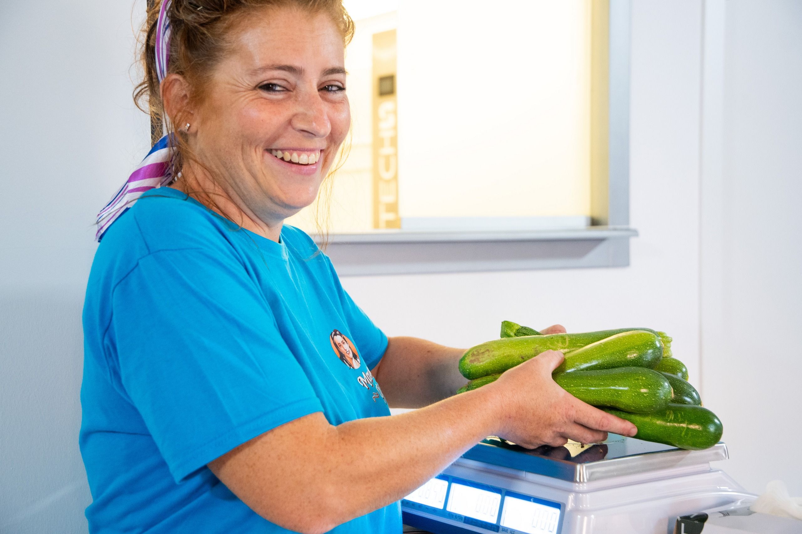 titolare con zucchine in mano nel punto vendita Mama Giò vendita prodotti naturali coltivati a km0 Mosciano Sant'Angelo di Teramo in Abruzzo